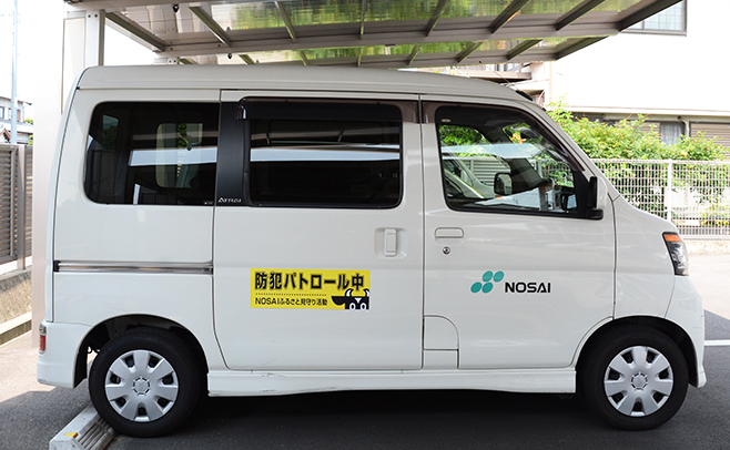 「防犯パトロール中」のステッカーを貼付した業務用車両の写真